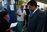 En kvinde ankommer til et hospital i Mexico City, hvor maskeklædte ansatte overvåger indgangen. 