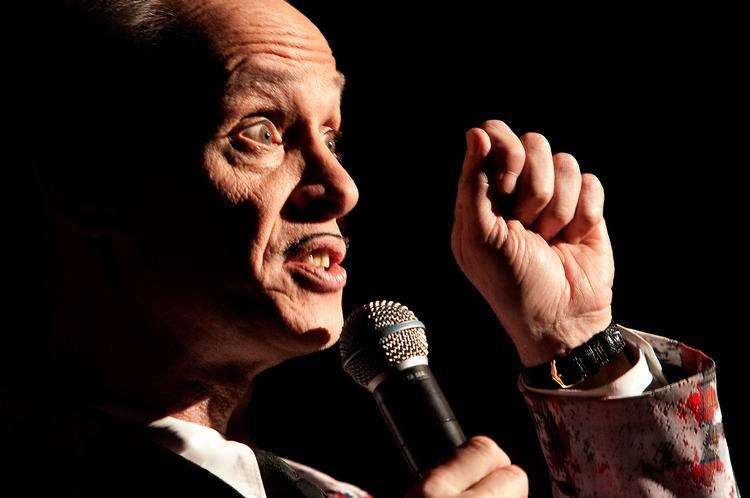 slam. Hvis det i hans levetid lykkes den amerikanske filmprovo John Waters at gøre slam, lurvethed og almindelige degeneration bare én procent mere spiselig, så er hans mission lykkedes. Siger han selv. Han prøvede i Glyptotekets Festsal. Foto: Jacob Ehrbahn
