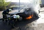 Brandfolk arbejder med at slukke bilen, der blev stukket i brand i Tingbjerg. 