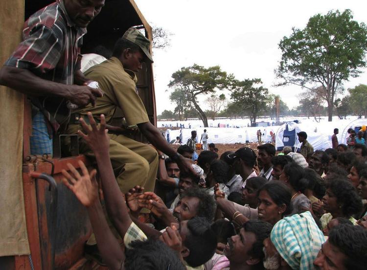 Dette foto er stillet til rådighed for Associated Press af den srilankanske hærledelse og viser soldater, der deler forsyninger ud til civile. 