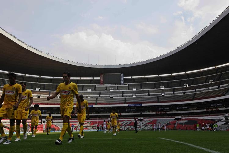 Americas spillere forlader banen på det tomme Aztec Stadium efter første halvleg. 