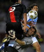 Målmanden Gaston Pezzutti har godt fat i Radamel Falcao Garcia fra River Plate i en kamp søndag. Senere i kampen lod målmanden sin frustration over et scoring til River Plate gå ud over en bolddreng. 