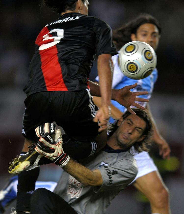 Målmanden Gaston Pezzutti har godt fat i Radamel Falcao Garcia fra River Plate i en kamp søndag. Senere i kampen lod målmanden sin frustration over et scoring til River Plate gå ud over en bolddreng. 
