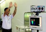 Vietnamesisk lufthavnsmedarbejder undersøger flypassagerer med thermokamera for at standse influenza-ramte.. 