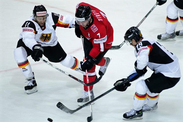 Schweiz' Mark Streit (midt) bryder gennem det tyske forsvar i kampen mellem de to lande ved VM. 