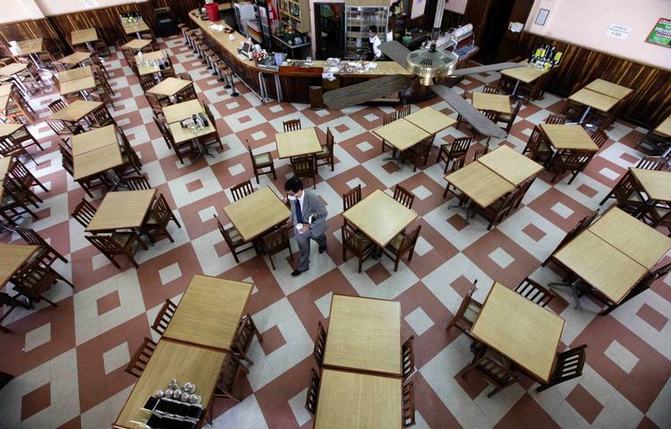 Svineinfluenzaen får mexikanerne til at holde sig fra større forsamlinger. Her en enlig gæst på en café i mexico By. 