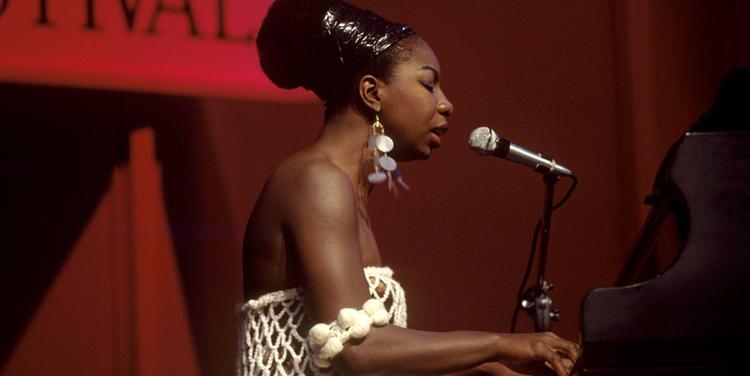NINA SIMONE. Hun var født i sydstaten North Carolina, men kom vidt omkring i sit liv. Fra New York flyttede hun til Afrika for at opleve sine rødder, og i de sidste år af sit liv slog hun sig ned i Sydfrankrig, hvor hun døde i 2003. Her ses hun ved en koncert i november 1961. 