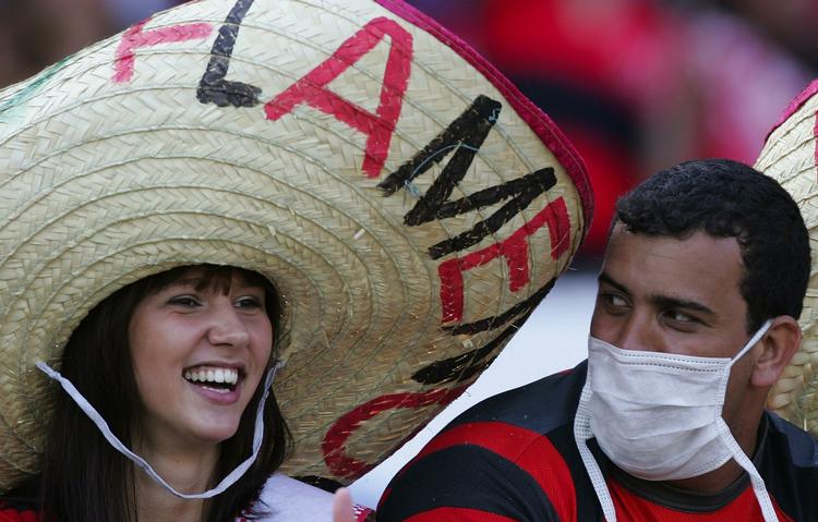 Svineinfluenzaen udgør fortsat en trussel, siger WHO. Men ikke alle tager det lige alvorligt. Disse fodboldfans i Brasilien forsøger - iført sombrero og ansigtsmaske - at  lægge lidt afstand til epidemiens alvor. 