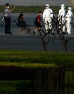 Mexicanere eskorteres ud til et ventende fly af kinesiske sundhedsarbejdere for at blive sendt til deres hjemland. 