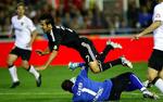 Real Madrids anfører Raúl bliver tacklet at Valencia-målmand Cesar. 