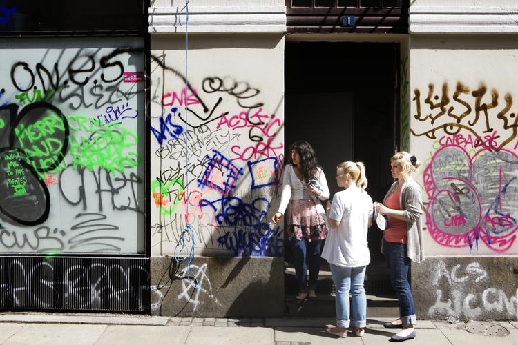Tre piger betragter skaderne efter Undoing the citys aktion i Hyskenstræde fredag nat. 