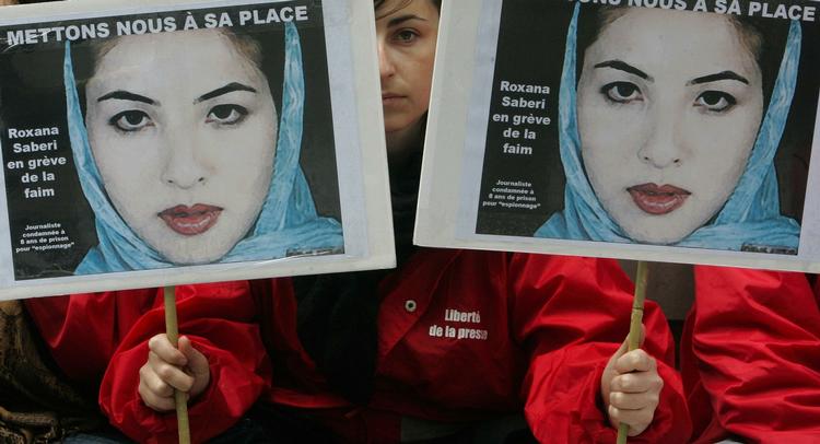 Fængslingen af Roxana Saberi har medført protester verden over. Her er det et medlem af organisationen 'Journalister uden grænser', der holder et banner med Saberis kontrafej ved en demonstration i Paris. Arkivfoto. 