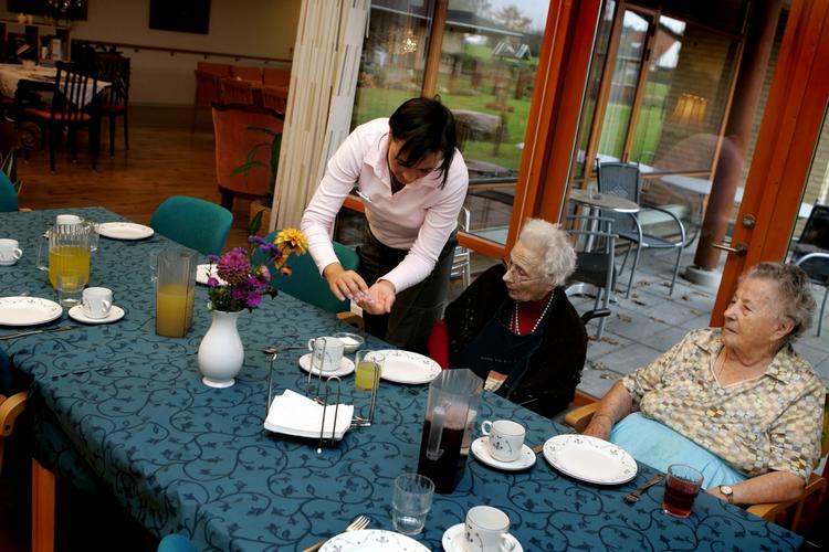 Sosu-assistent Charlotte Marquart  er ved at servere frokost for beboerne Hanna og Marie på Koltgården. (Arkivfoto) 