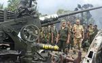 Regeringssoldater i Sri Lanka betrager  våben, som de har erobret fra De Tamilske Tigre, der i weekenden opgav deres årelange væbnede oprør. 