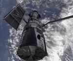 Rumteleskopet Hubble var målet for Atlantis-missionen. Her ses Hubble blive holdt af rumfærgens robotarm. 