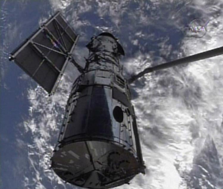 Rumteleskopet Hubble var målet for Atlantis-missionen. Her ses Hubble blive holdt af rumfærgens robotarm. 