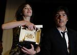 Charlotte Gainsbourg viser sin pris frem. Til højre gemalen, den franske skuespiller Yvan Attal. 