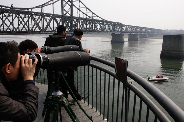 Kinesere spejder mod Nordkorea ved bro, som forbinder de to lande. (Arkivfoto) 