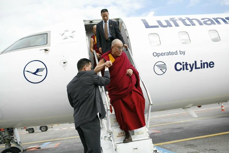 Dalai Lama, der efterhånden er en aldrende herre, fik en hjælpende hånd, da han skulle ned af trappen. 