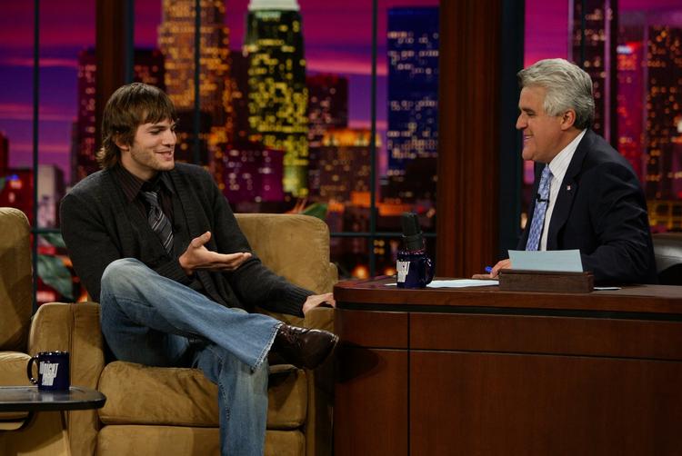Tv-værten, som seerne kender ham, bag sit skrivebord i The Tonight Show. Her med Ashton Kutcher. Nu får Jay Leno sit eget show, der bærer hans navn. 