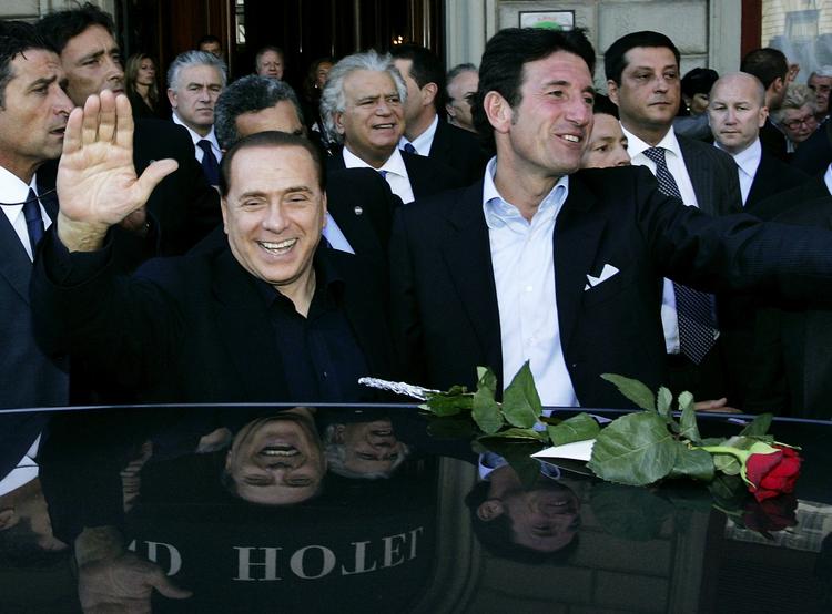 Italiens premierminister Silvio Berlusconi (tv) hilser på tilhængere under et valgmøde i Firenze tirsdag. Berlusconi forsøger at hjælpe den tidligere Milan-målmand Giovanni Galli (th) i kampen for at blive borgmester i byen. Arkivfoto. 
