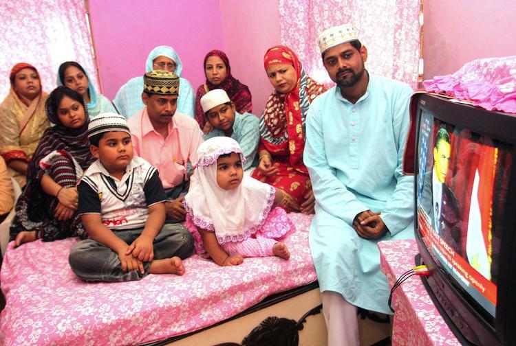 En muslimsk familie i Indien er samlet for at se den 45 minutter lange tale. 