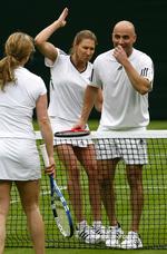 Den tidligere tennisstjerne André Agassi under Roger Federer, at få den fjerde grand slam-titel i hus. Her ses Agassi (th) under en testkamp på Wimbledons græs 17. maj sammen med en anden tidligere tennisstjerne, Steffi Graf, som deler hus, hjem og barn med Agassi. Arkivfoto. 