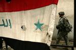 En amerikansk soldat passerer det irakiske flag i byen Mosul. Arkivfoto 