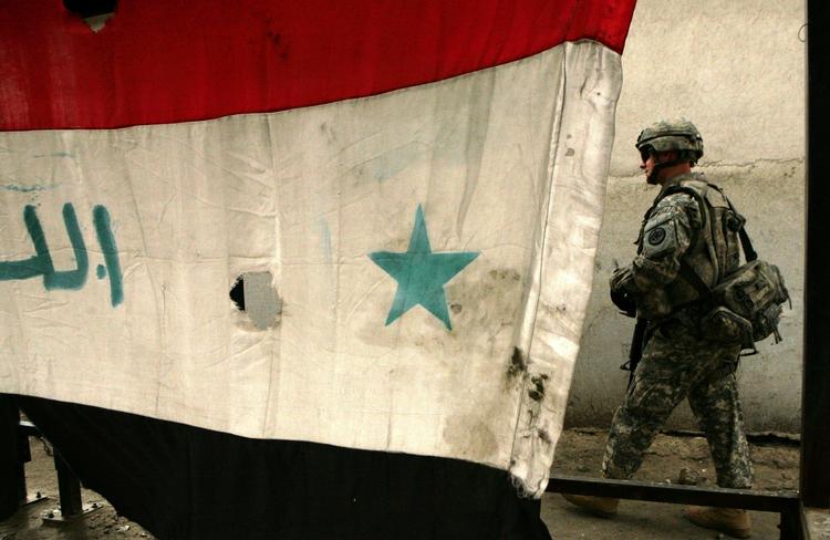 En amerikansk soldat passerer det irakiske flag i byen Mosul. Arkivfoto 