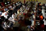 Netbrugere - som disse gæster i en internetcafe i Beijing - kan nu tage en universitetsuddannelse via nettet. Arkivfoto. 