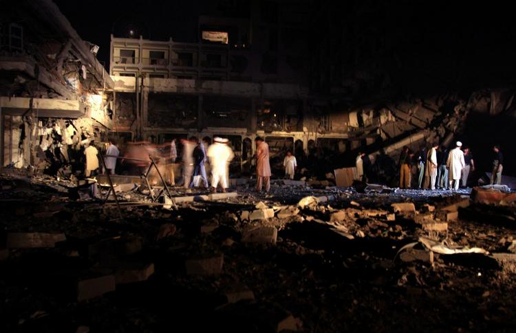 Redningsfolk søger efter mennesker i murbrokkerne, efter at en bombe ramte et hotel i Peshawar. 