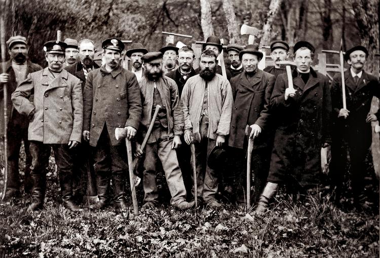 De alvorstunge ansigter fortæller bedre end ord, at det var et af samfundets hårdeste job at være skovarbejder før mekaniseringens tid. Foto: Cirka 1910, fra bogen