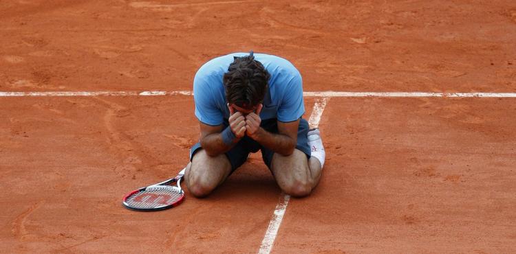 En lykkelig Roger Federer bøjer sig i det røde grus efter sejren over svenske Robin Söderling i French Open-finalen. Arkivfoto. 