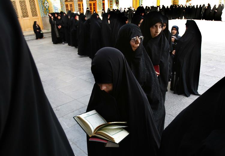 Kvinder i chador venter på at stemme ved præsidentvalget i Iran. 