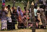 Civile står bag et pigtrådshegn ved en flygtningelejr i det nordlige Sri Lanka. 