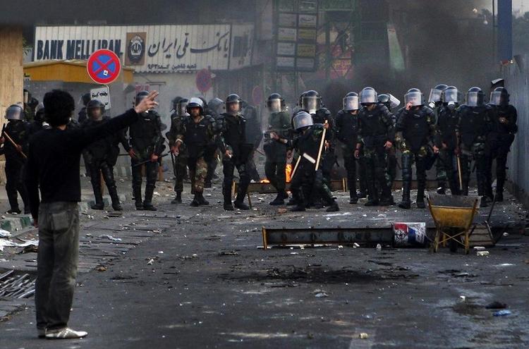 Lørdag slog politiet hårdt ned på demonstranterne, og flere blev dræbt. Den IranskeRevolutionsgarde truer med at slå hårdt ned på fremtidige protester. 