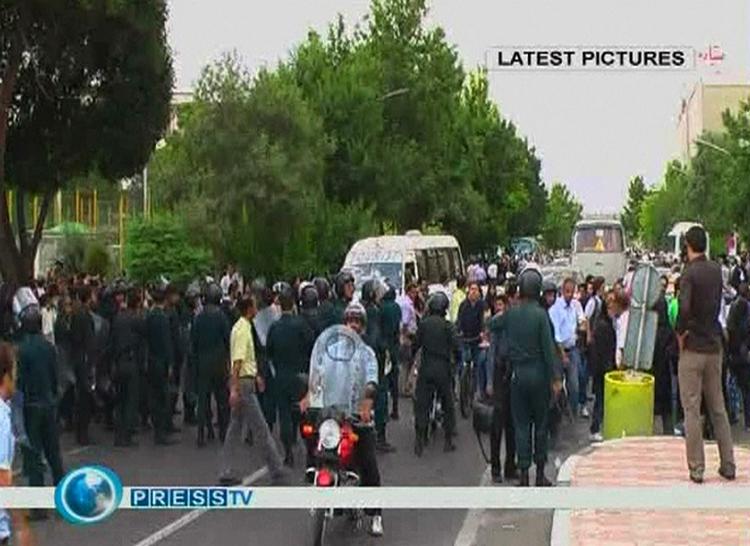 Billedet taget fra det iranske Press TV. Sikkerhedsfolk og demonstranter på gaden i går, 24. juni. 