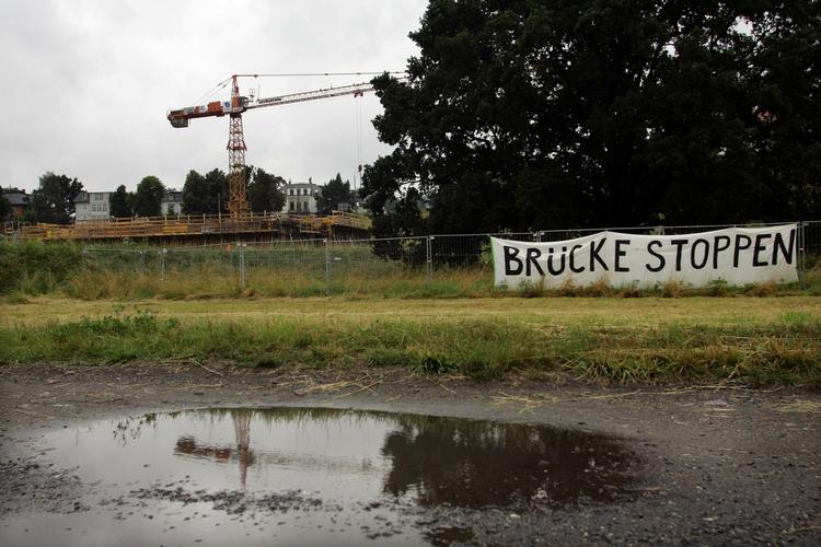 Byggekranerne - og et protestbanner - ved Dresden, hvor den smukke Elben-dal nu skal skæres over af en motorvejsbro. 