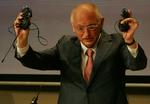 EUs industri-kommissær Guenter Verheuge glæder sig over, at forbrugerne fremover slipper for at skulle rode med en speciel oplader til hvert enkelt apparat. Her ses han med nogle stykker af slagsen. 