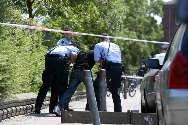 Politifolk hjælper den dræbtes bror væk fra gerningsstedet kort efter drabet. 