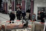Politi med hunde  leder efter spor foran juicebaren, hvor HA-rockeren Brian Sandberg blev forsøgt likvideret. I dag blev den ene af attentatmændene sigtet - han sad allerede i fængsel for en anden forbrydelse. Arkivfoto. 