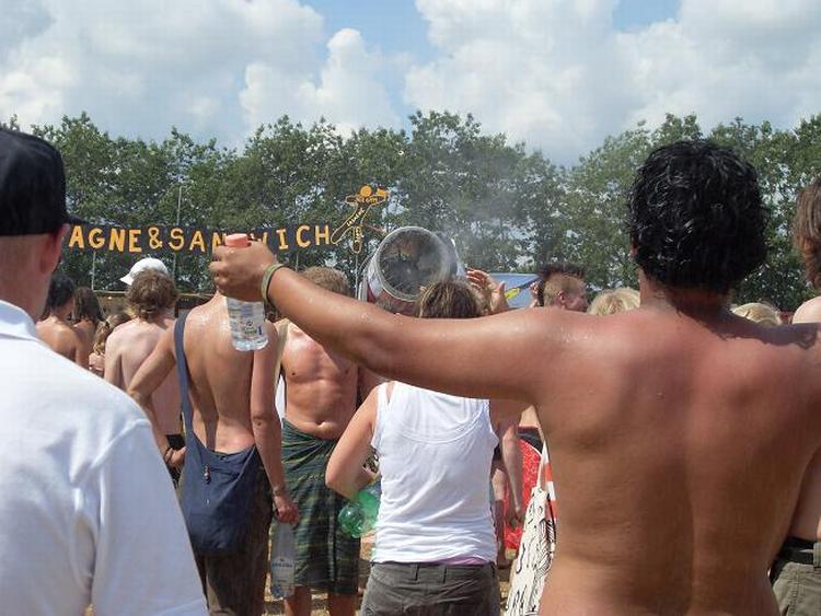 Svedige gæster samler sig foran snekanonen på Roskilde, som køler dem ned. 