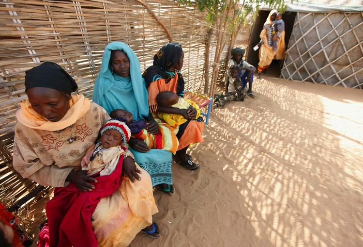 Hjemløse sudanesiske kvinder og børn venter på at få behandling på en lægeklinik i en flygtningelejr. 