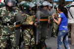 En kvinde, der tilhører minoriteren uighur, protesterer foran en gruppe soldater i Xinjiang-byen Urumqi. 