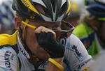 Lance Armstrong tager solbrillerne af i regnen på dagens krævende rute. 
