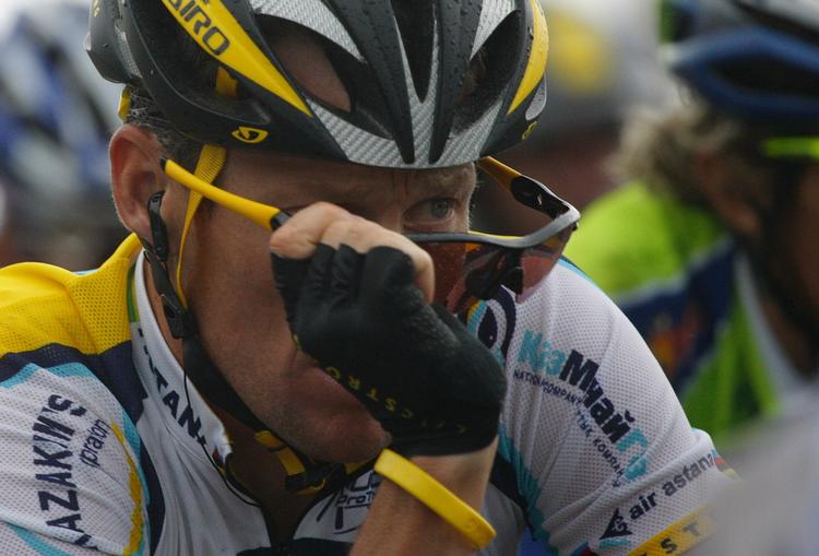 Lance Armstrong tager solbrillerne af i regnen på dagens krævende rute. 
