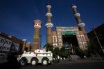 En kinesisk kampvogn holder vagt foran en moske i Urumqi. 
