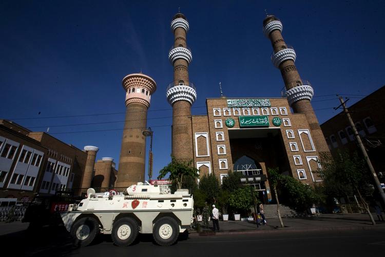 En kinesisk kampvogn holder vagt foran en moske i Urumqi. 