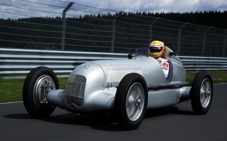 Lewis Hamilton kører så langsomt i denne sæson, at det virker, som om han stiller op i en Mercedes W25 Sølvpil som denne. Der er dog blot tale om et reklamefremstød før det tyske grandprix i dag på Nürburgring. Foto: Wolfgang Wilhelm/AP 
