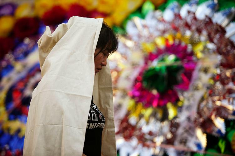 En slægtning til han-kinesere, der har mistet livet under urolighederne i Kinas Xinjiang-region, i sorg ved deres begravelse 